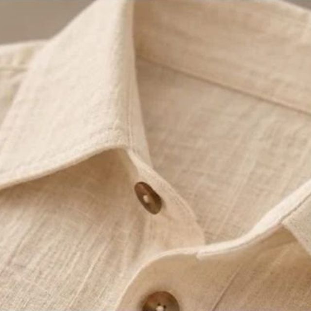 The collar and placket of an ivory textured linen shirt