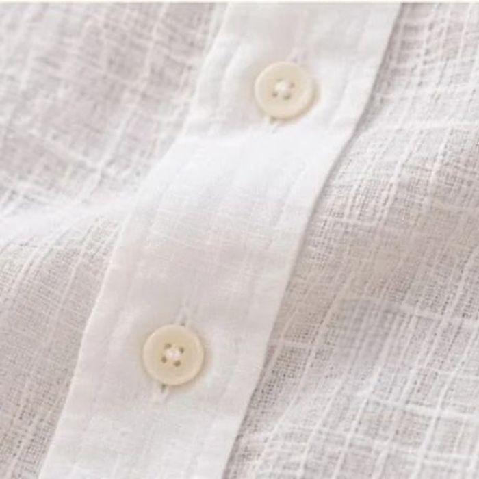 The finished collar of an ivory linen shirt